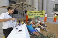 Activistas de Greenpeace han instalado una playa a la entrada del Ministerio de Medio Ambiente, en Madrid, como protesta contra la reforma de la Ley de Costas. EFE