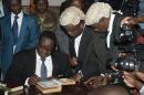 Newly elected Malawian President Peter Mutharika signs a document as he takes an oath of office at the High Court on May 31, 2014, in Blantyre, Malawi