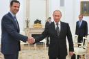 Russian President Vladimir Putin (R) shakes hands with embattled Syrian leader Bashar al-Assad in a meeting at the Kremlin in Moscow on October 20, 2015