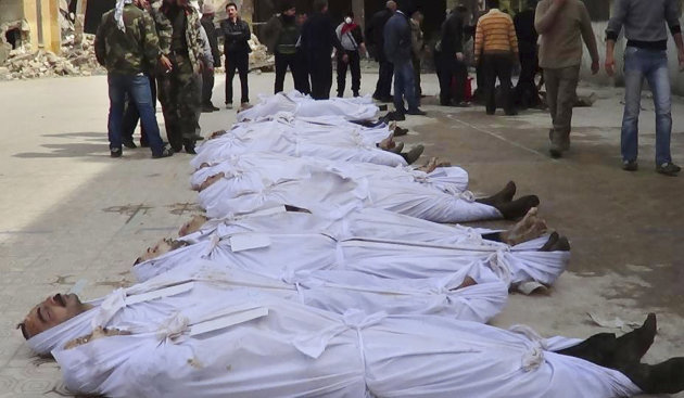 This citizen journalism image taken on, Sunday, March. 10, 2013 and provided by Aleppo Media Center AMC which has been authenticated based on its contents and other AP reporting, shows Syrians standing next to dead bodies that have been pulled from the river near Aleppo's Bustan al-Qasr neighborhood, Syria. Activists said the dead bodies of at least 20 men were pulled from a river that runs between regime- and rebel-controlled parts of the northern city. (AP Photo/Aleppo Media Center AMC)