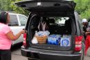 Aundrea Simmons stands next to her minivan with cases of bottled water she bought after Toledo warned residents not to use its water, Saturday, Aug. 2, 2014 in Toledo, Ohio. About 400,000 people in and around Ohio's fourth-largest city were warned not to drink or use its water after tests revealed the presence of a toxin possibly from algae on Lake Erie. (AP Photo John Seewer)