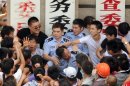 Chinese protesters beat police officers during clashes outside the local government offices in Qidong