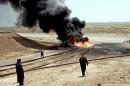 Members of the oil protection police secure the site of a burning oil pipeline near the northern city of Kirkuk, 03 July 2006
