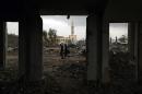 Palestinians walk near the ruins of a house destroyed by Israeli shelling during a 50-day war in the summer of 2014, in the northern Gaza Strip town of Beit Lahia on February 19, 2015