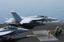 This US Navy handout photo shows sailors directing F/A-18E Super Hornets attached to the Fighting Black Lions of Strike Fighter Squadron (VFA) 213 on the flight deck of the aircraft carrier USS George H.W. Bush on August 1, 2014 in the Gulf