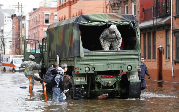 A man carries his wife through the floodwaters to a National Guard truck in Hoboken, New Jersey