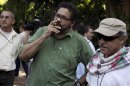 Revolutionary Armed Forces of Colombia'slead negotiator Ivan Marquez smokes a Cohiba cigar next to FARC negotiator Jesus Santrich after a conference in Havana