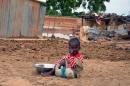 A child sits near the ruins of his parents' home on September 5, 2013, in Niamey, Niger, where floods caused 26 casualities and affected 75,347 people