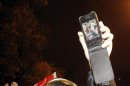 Un bombero muestra en su teléfono móvil la fotografía del joven que ha resultado herido en la cabeza durante una carga policial en Tarragona. EFE/Archivo