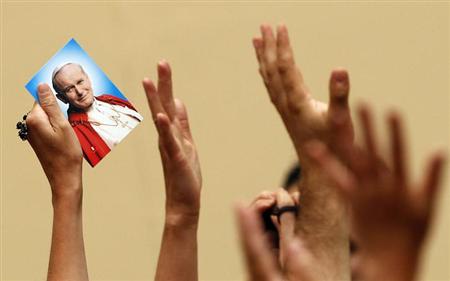 A picture of the late Pope John Paul II is held up as Pope Benedict XVI leads the Angelus prayer from his summer residence of Castel Gandolfo July 29, 2012. REUTERS/Alessandro Bianchi/Files