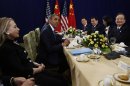 U.S. President Obama meets with Chinese Premier Wen, as Secretary of State Clinton looks on, at the East Asia Summit in Phnom Penh