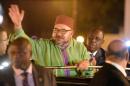 Moroccan King Mohammed VI (C) waves to the crowd eyed by Senegalese president Macky Sall upon his arrival at Dakar's airport on November 6, 2016