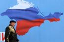 A man walks past a poster in Sevastopol on March 11, 2014 depicting Crimea in the colors of the Russian flag