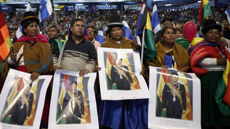 Aymara women hold a posters of Bolivia's President Evo Morales during a welcome ceremony for presidents attending an extraordinary meeting in Cochabamba, Bolivia, Thursday, July 4, 2013. Leaders of Uruguay, Ecuador, Surinam, Argentina and Venezuela are meeting in Bolivia Thursday in support of Morales, who said Thursday that the rerouting of his plane in Europe, over suspicions that National Security Agency leaker Edward Snowden was on board was a plot by the U.S. to intimidate him and other Latin American leaders. (AP Photo/Juan Karita)
