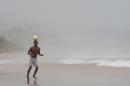 A man heads a soccer ball during a stroll along the beach on a rainy day in Natal, Brazil, Saturday, June 14, 2014. Natal is one of 12 cities hosting games during the 2014 World Cup soccer tournament. (AP Photo/Julio Cortez)