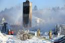 Canadian firefighters douse the burnt remains of a retirement home in L'Isle-Verte on January 23, 2014
