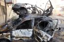 An Iraqi man inspects the wreckages of burnt cars on May 1, 2015 a day after a car bomb attack in the Baghdad neighbourhood of Talbiya