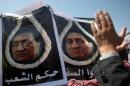 Posters show Egypt's ousted president Hosni Mubarak in a noose on August 3, 2011 outside a hearing in his trial in the Cairo Police Academy
