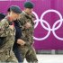 Members of the armed forces walk past the Olympic rings on the perimeter of the Olympic Park in Stratford, east London