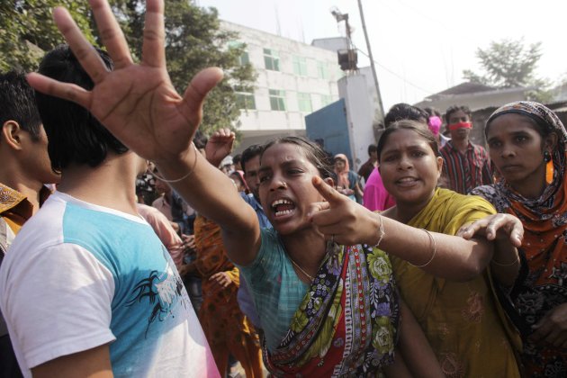 Workers shout slogans as they protest against the death of their colleagues after a devastating fire in a garment factory which killed more than 100 people, in Savar November 26, 2012. Thousands of angry textile workers demonstrated in the outskirts of Dhaka on Monday after a fire swept through a garment workshop at the weekend, killing more than 100 people in Bangladesh's worst-ever factory blaze.  REUTERS/Andrew Biraj (BANGLADESH - Tags: DISASTER BUSINESS TEXTILE EMPLOYMENT CIVIL UNREST)