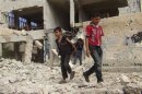 Children walk among debris from a damaged school building in the Damascus suburb of Zamalka