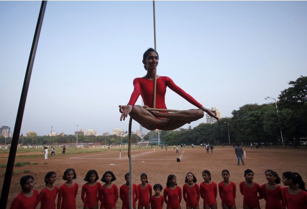 A girl practices a Mallakhamb pose while suspended from a rope at the Shree Samartha Vyayam Mandir in Mumbai