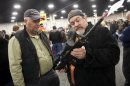 FILE - In a Saturday, Jan. 5, 2013 file photo, gun owners discuss a potential sale of an AR-15, during the 2013 Rocky Mountain Gun Show at the South Towne Expo Center in Sandy, Utah. Nearly six in 10 Americans want stricter gun laws in the aftermath of last month's deadly school shooting in Connecticut, with majorities favoring a nationwide ban on military-style, rapid-fire weapons and limits on gun violence depicted in video games and movies and on TV, according to a new Associated Press-GfK poll. A lopsided 84 percent of adults would like to see the establishment of a federal standard for background checks for people buying guns at gun shows, the poll showed. President Barack Obama was set Wednesday, Jan. 16, 2013 to unveil a wide-ranging package of steps for reducing gun violence expected to include a proposed ban on assault weapons, limits on the capacity of ammunition magazines and universal background checks for gun sales.(AP Photo/The Deseret News, Ben Brewer, File) NO SALES; MAGS OUT; SALT LAKE TRIBINE OUT; PROVO DAILY HERALD OUT