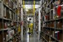 Worker gathers items for delivery from the warehouse floor at Amazon's distribution center in Phoenix