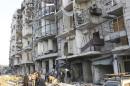 Residents inspect damage after what activists said was a barrel bomb dropped by forces loyal to Syria's President Bashar al-Assad in the Tariq al-Bab neighbourhood of Aleppo