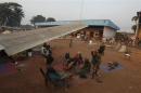 A family displaced by inter-communal violence in the country sit near a plane in a camp for displaced persons at Bangui M'Poko International Airport