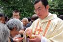 Rev. Thaddeus Ma Daqin gives the holy communion to a woman at Sheshan Cathedral, Shanghai