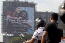 Motorists ride past a billboard displaying Facebook's Free Basics initiative in Mumbai, India