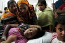Merina, a survivor of the garment factory building collapse, is comforted by family members in hospital on Saturday April 27, 2013 in Savar, near Dhaka, Bangladesh. Merina was trapped under rubble for three days, surviving with nothing to eat and only a few sips of water. The building collapse was the worst disaster to hit Bangladesh's $20 billion a year garment industry.(AP Photo/Gillian Wong)