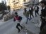 File photo of residents running to take cover as Free Syrian Army fighters take their position behind sandbags during clashes with forces loyal to Syria's President Bashar Al-Assad in Aleppo'
