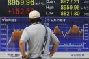 A man looks at an electronic stock indicator in Tokyo Wednesday, Sept. 12, 2012 as Japan's Nikkei 225 index rose 1.7 percent to close at 8,959.96. (AP Photo/Shizuo Kambayashi)