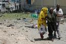 A wounded woman is helped at the scene of a car bomb outside the Education Ministry in Mogadishu on April 14, 2015
