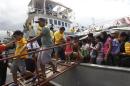 Survivors of super Typhoon Haiyan disembark from a Philippine Navy ship upon arrival at the north harbor in Manila
