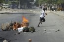 Protester runs in front of a burning barricade in Zanzibar