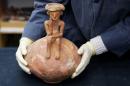 Journalists are shown a 3,800 year-old pottery jug with a rare statuette, discovered during excavation in central Israel, at the Israel Antiquities Authority offices in Jerusalem