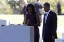 Obama and first lady Michelle look at the headstone of a grave during their visit to Arlington National Cemetery on the 11th anniversary of the 9/11 attacks near Washingto