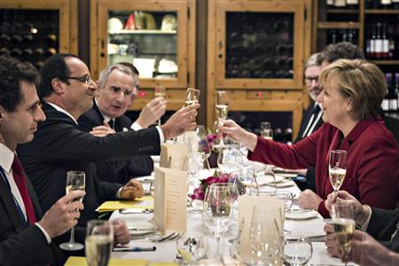 German Chancellor Merkel and French President Hollande salute to each other during a private dinner in a Berlin restaurant