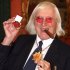 FILE - This March 25, 2008 file photo shows Jimmy Savile holding a medal in London. At Savile's funeral in 2011, the priest delivering the homily was emphatic: the DJ and television host "can face eternal life with confidence." But a year on, Savile's reputation is in ruins. Police have branded him one of Britain's worst sex offenders, accused of assaulting underage girls over half a century. Like those who feted and praised him on that November day, millions are wondering: How could he have duped so many for so long? (AP Photo/Lewis Whyld/PA Wire)