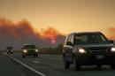 The setting sun is partially obscured by smoke from an out of control wildfire on the Parks Highway near Willow, Alaska