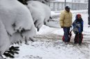 People walk in the snow at Buffalo Niagara International Airport in Buffalo, N.Y., Saturday, Dec. 29, 2012. A mild but widespread winter storm has developed over the Northeast and the upper Ohio River Valley, the second in less than a week for the regions. (AP Photo/Mel Evans)