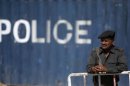 A policeman stands guard at a road which has been blockaded with a container due to increased security measures in Karachi