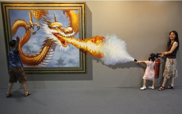 Members of a family pose for a photograph in front of a 3D painting at 2012 Magic Art Special Exhibition in Hangzhou