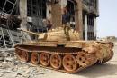 Members of the Libyan pro-government forces stand on a tank in Benghazi
