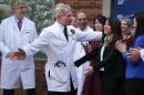 Director of the National Institute of Allergy and Infectious Diseases Anthony Fauci (2nd L) hugs Nina Pham (5th L), the nurse who was infected with Ebola from treating a patient