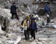 Turkish boys walk past a collapsed building in Ercis