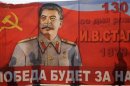 File photo of people casting shadows on a poster with a portrait of the Soviet dictator Josef Stalin during a May Day rally in Volgograd